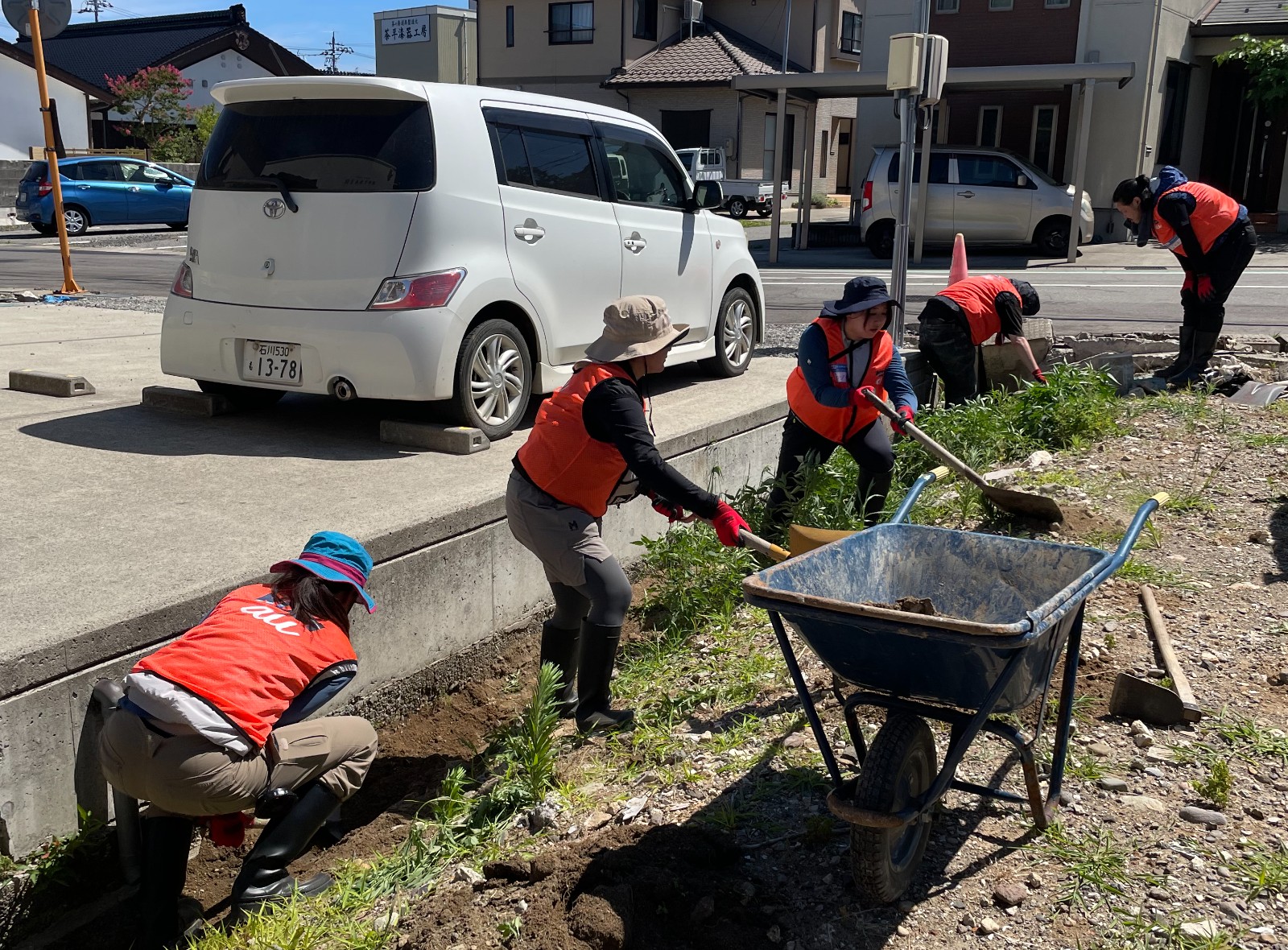 側溝に溜まった泥をかき出す様子の写真