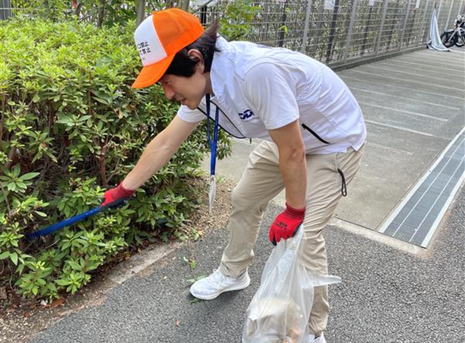 歩道のゴミを拾う様子の写真